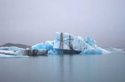 Scenic view of ice floating on sea against sky