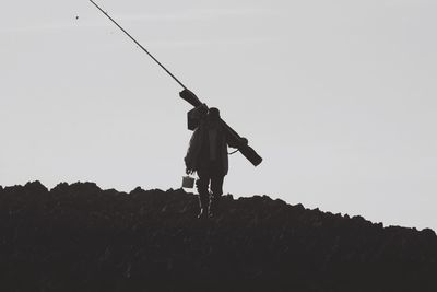 Low angle view of silhouette boy against clear sky