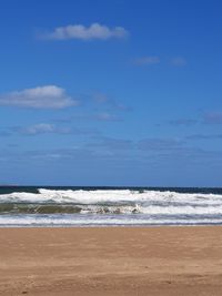 Scenic view of beach against blue sky