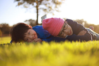 Portrait of siblings lying on field