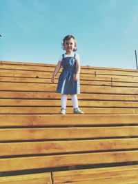 Full length of woman on wooden staircase against sky