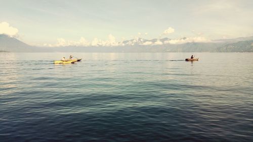 Man on boat in sea against sky