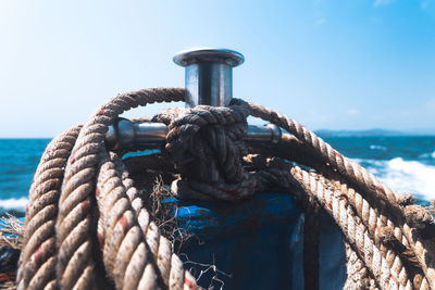 Close-up of rope tied to bollard against sky