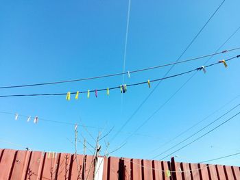 Low angle view of cables against clear blue sky