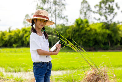 Woman with umbrella standing on field