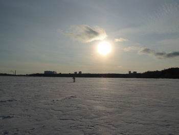 Scenic view of frozen landscape against sky during sunset