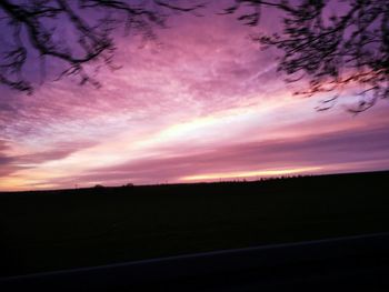 Scenic view of silhouette field against sky at sunset