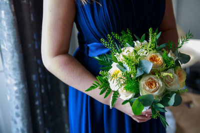 Midsection of woman holding flower bouquet