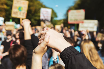 Midsection of people holding hands at music festival