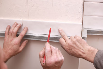 Cropped hand of woman drawing on wall