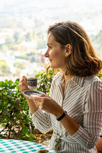 Young woman enjoys a cup of turkish coffee in istanbul on vacation