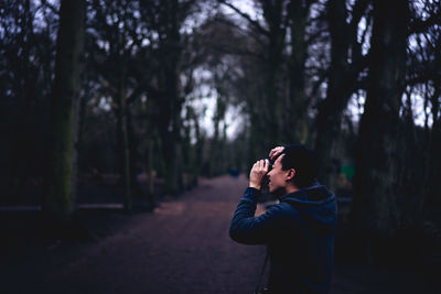 Man standing on tree trunk in forest