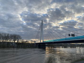 Bridge over river against sky during winter