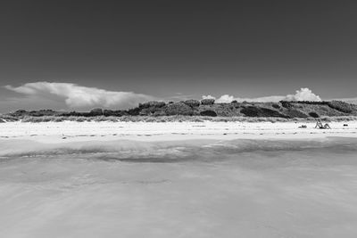 Scenic view of sea and snowcapped mountains against sky