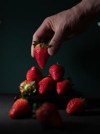 Close-up of hand holding strawberries