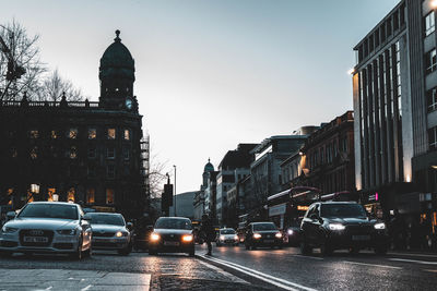 Traffic on road amidst buildings in city