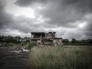 Old ruin on field against cloudy sky