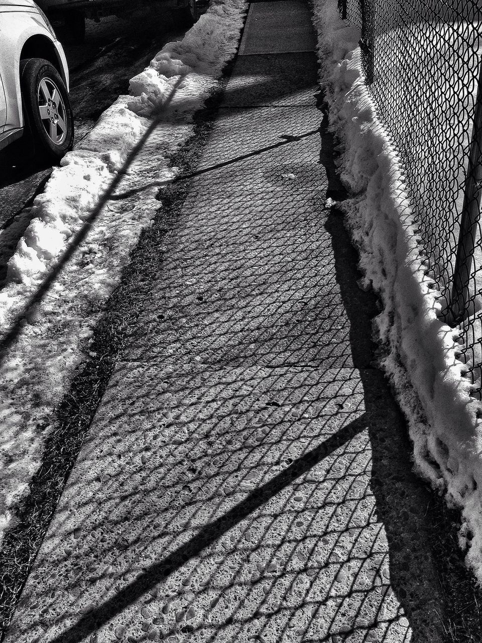 shadow, pattern, sunlight, textured, outdoors, day, no people, street, footpath, high angle view, fence, tree, railing, metal, cobblestone, transportation, close-up, nature, full frame, wall - building feature