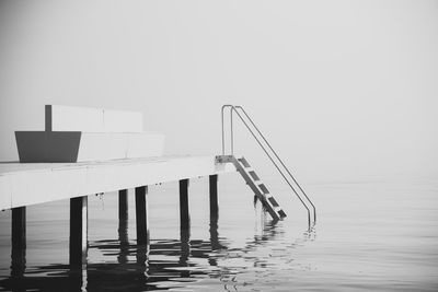 Swimming pool by sea against clear sky