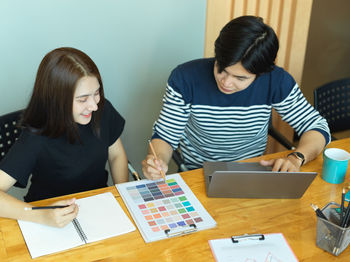 Businesswoman wearing mask having discussion with colleague