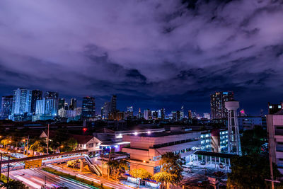 High angle view of light trails on street amidst buildings at night