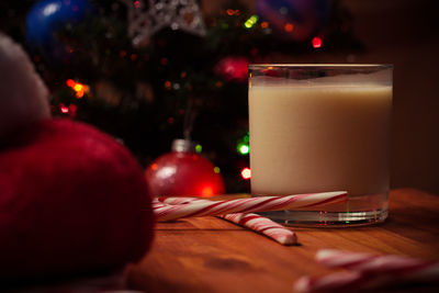 Close-up of drink by candy canes in glass on table