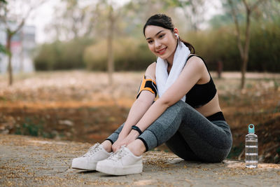 Portrait of a smiling young woman sitting on land