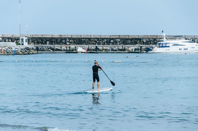 Man surfing in sea against sky