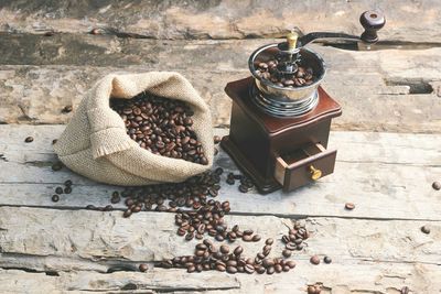 High angle view of coffee beans and grinder on table