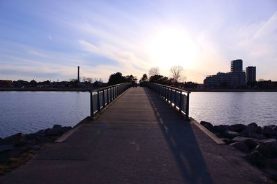 Bridge over river against sky in city