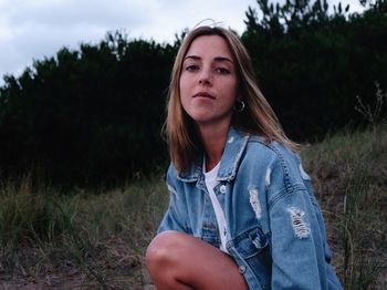 Portrait of young woman sitting on field