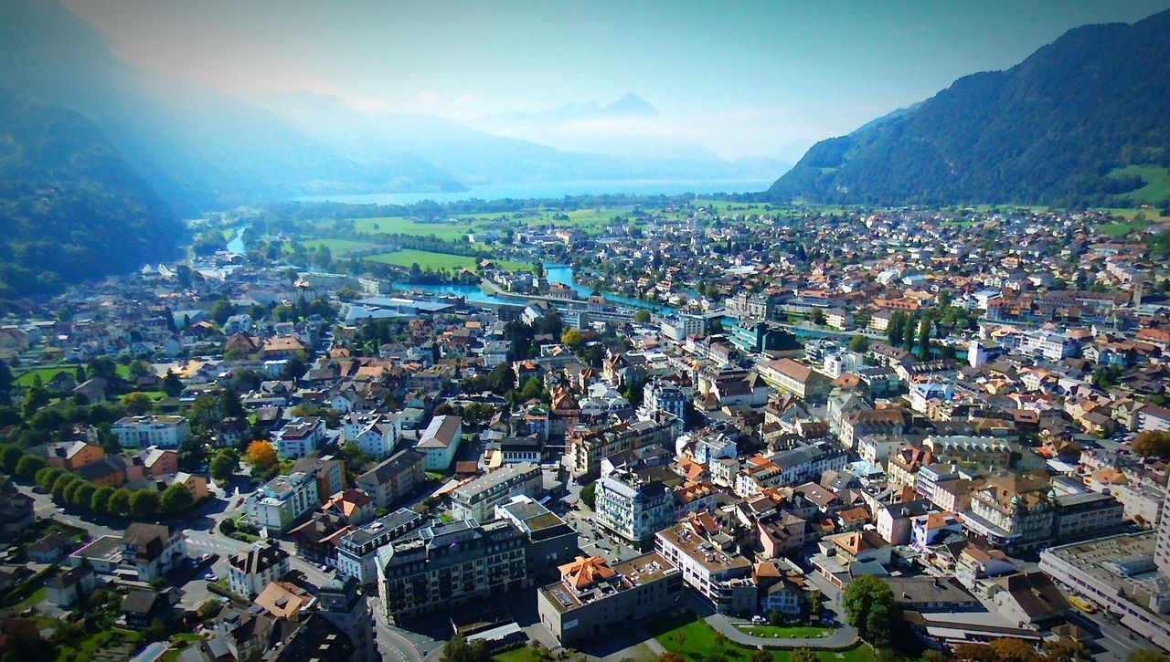 architecture, building exterior, built structure, cityscape, high angle view, crowded, mountain, city, residential district, residential building, aerial view, residential structure, sky, townscape, town, landscape, mountain range, community, house, human settlement