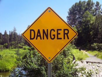 Close-up of road sign against trees