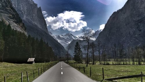 Road amidst trees against sky