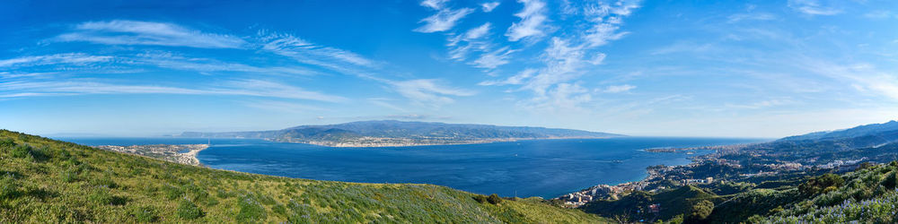 Scenic view of sea and mountains against blue sky