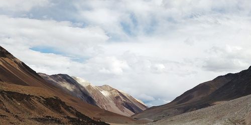 Scenic view of mountains against cloudy sky