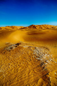 Scenic view of desert against clear blue sky