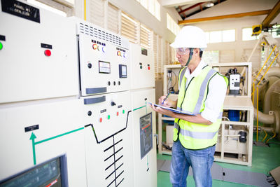 Maintenance engineers inspect relay protection system. bay control unit. medium voltage switchgear