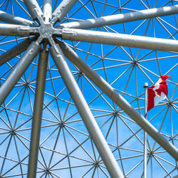 Low angle view of ferris wheel against blue sky