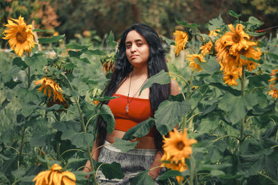 Portrait of beautiful woman standing amidst plants