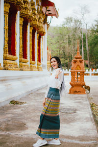 Woman standing outside temple against building