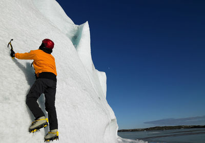 Rear view of man on snow against sky