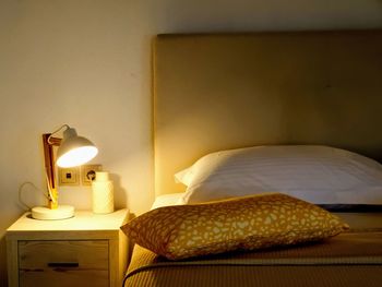 View of electric lamp on bed against wall at home