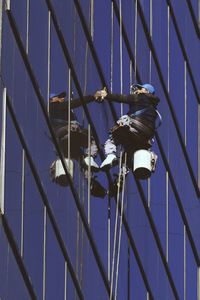 Low angle view of man cleaning modern building