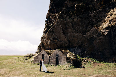 View of rock formation on field against sky