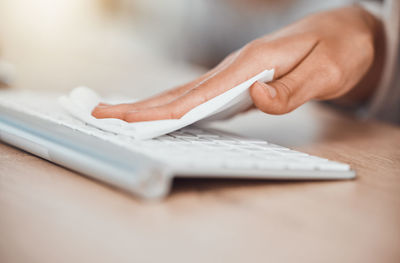 Cropped hand of person using laptop on table