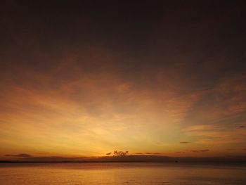 Scenic view of sea against dramatic sky during sunset