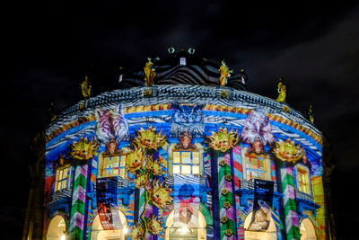 Low angle view of illuminated ferris wheel at night