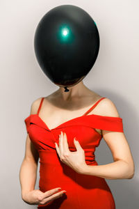 Midsection of woman wearing top against white background