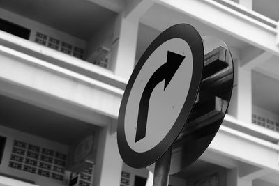 Low angle view of road sign against built structure